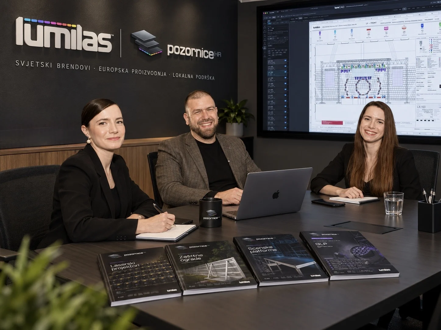 Team around a table with catalogues and a stage design